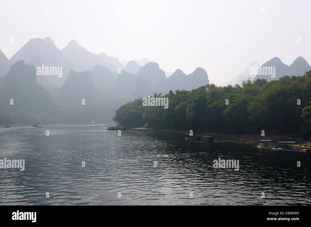 Les bateaux d'excursion sur la rivière Li Guangxi Chine Avec montagnes karstiques Dome dans la brume Banque D'Images