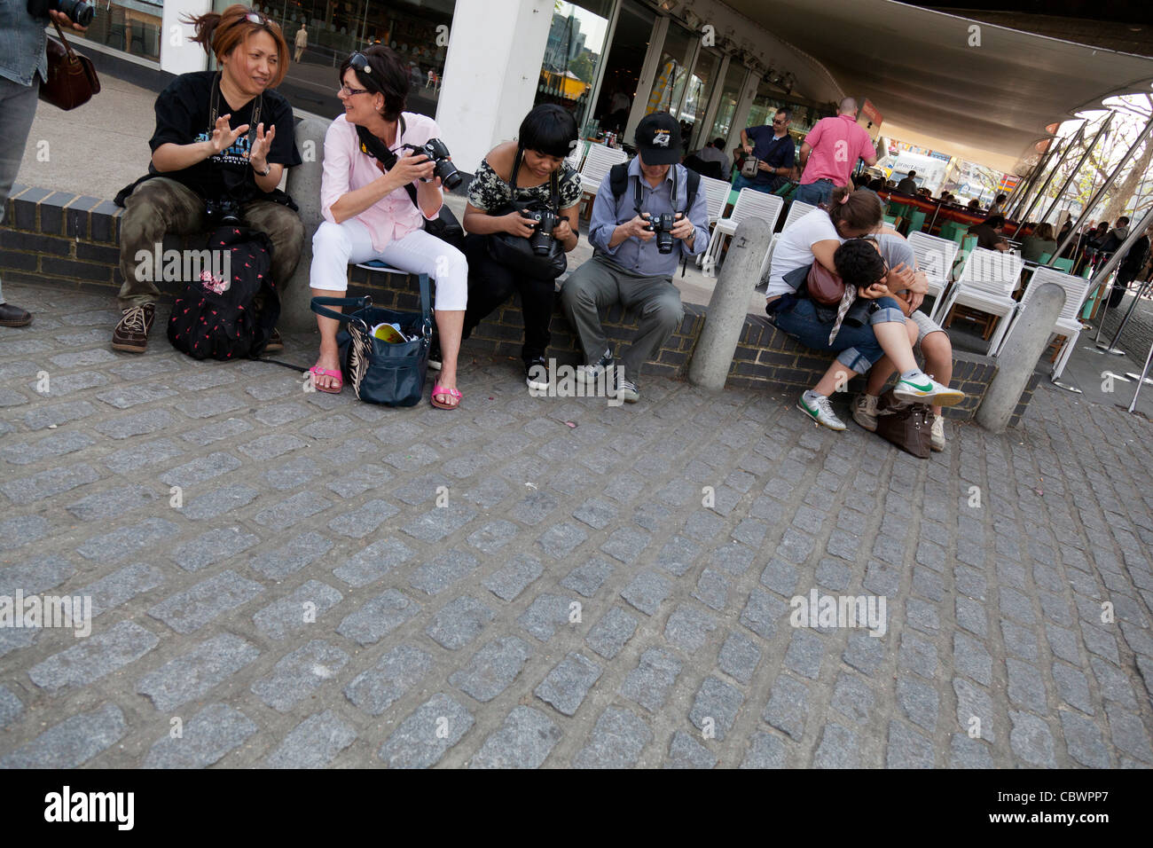 Les touristes chat et vérifier leurs caméras. Banque D'Images