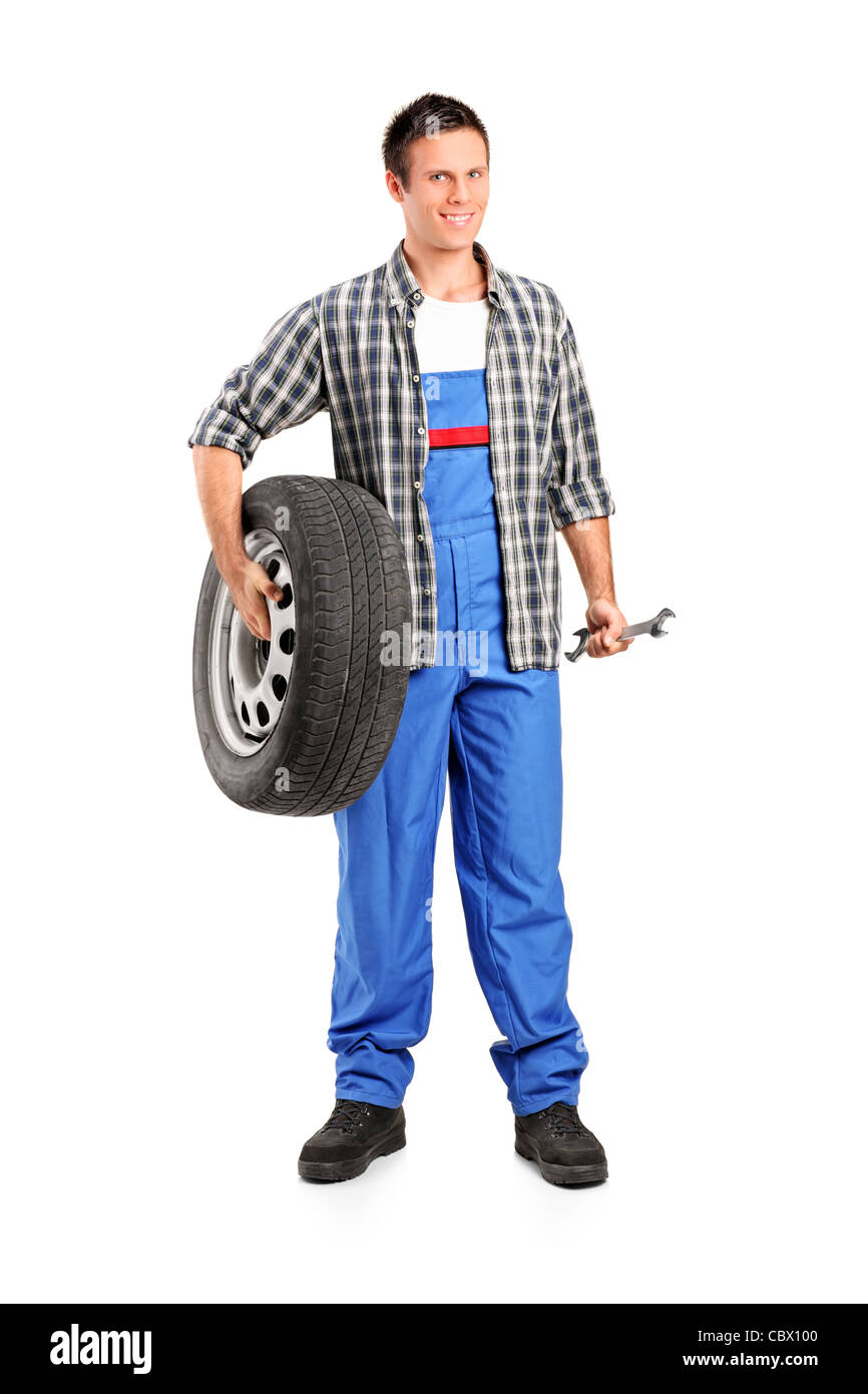 Portrait d un mecanicien tenant une roue de secours et la tenue d une cle Photo Stock Alamy