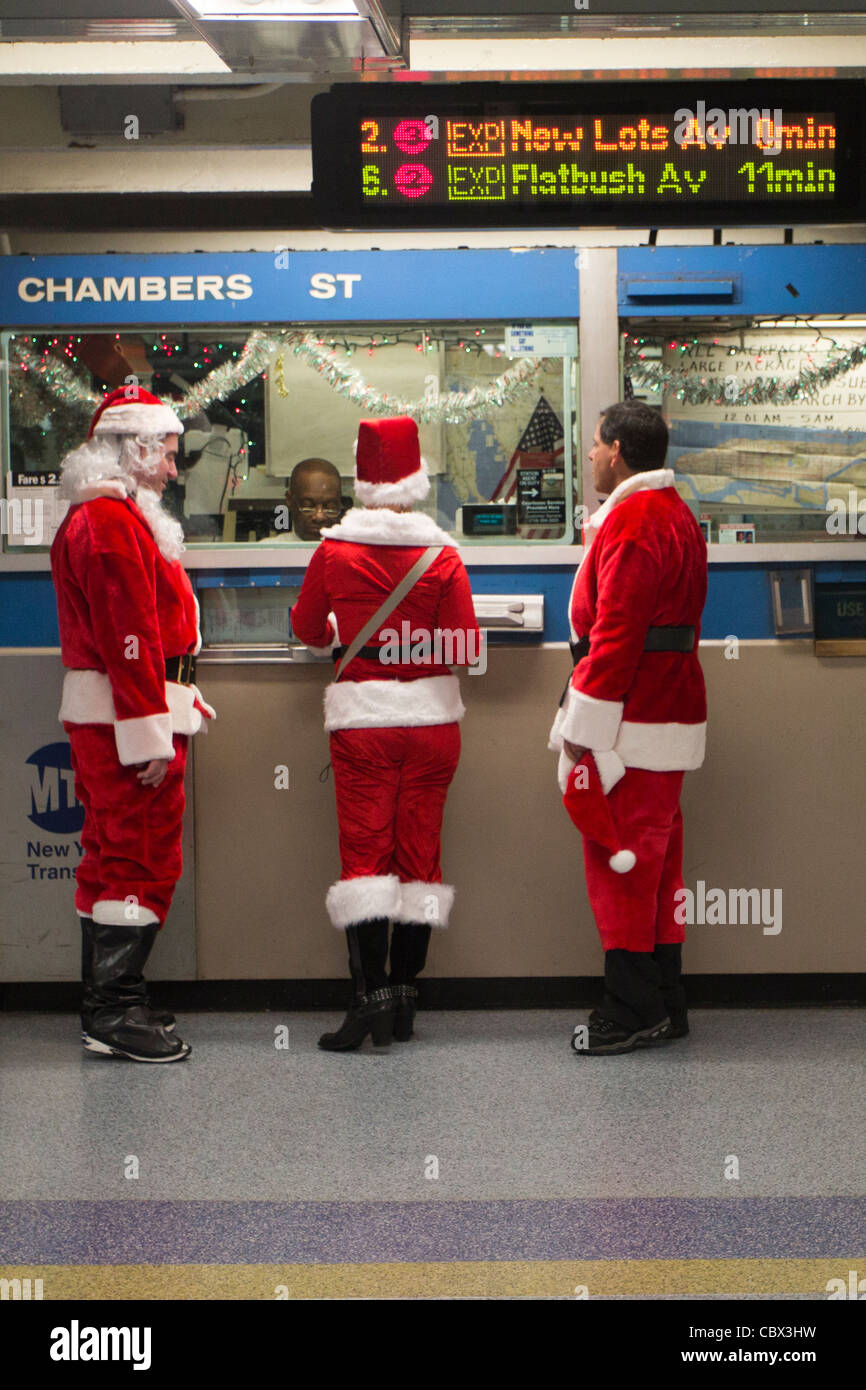 Trois Pères Noël sur le chemin de l'Santacon 2011 à New York City acheter au MetroCards Chambers Street subway station Banque D'Images