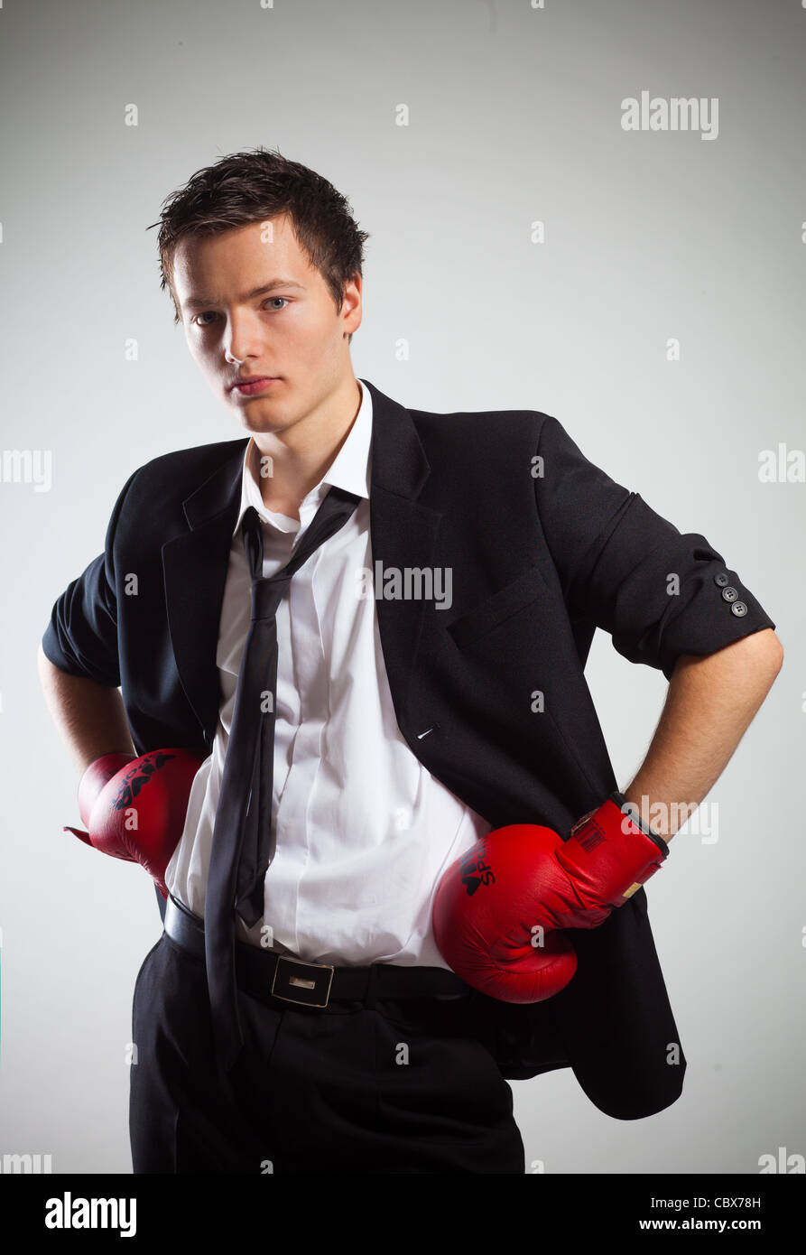 Businessman Wearing Boxing gloves, sur fond gris Banque D'Images