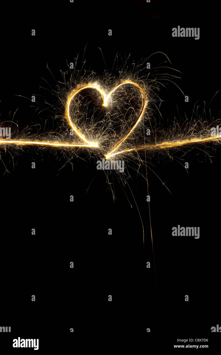 Forme de coeur fait avec sparkler la nuit. Banque D'Images