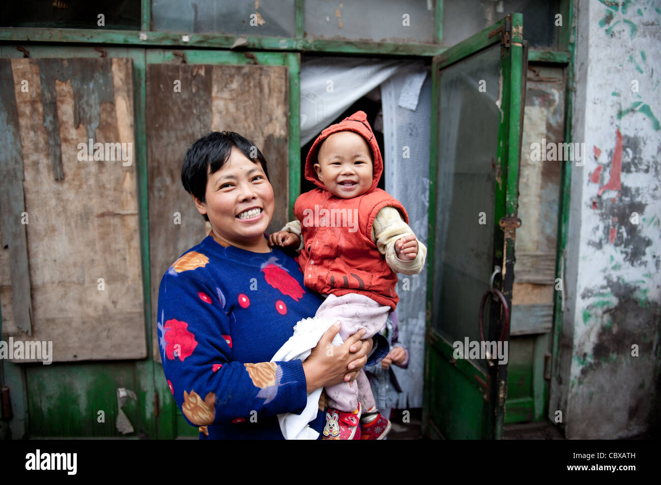 Pingyao. La mère et l'enfant devant leur maison dans l'ancien centre ville de Pingyao. Banque D'Images