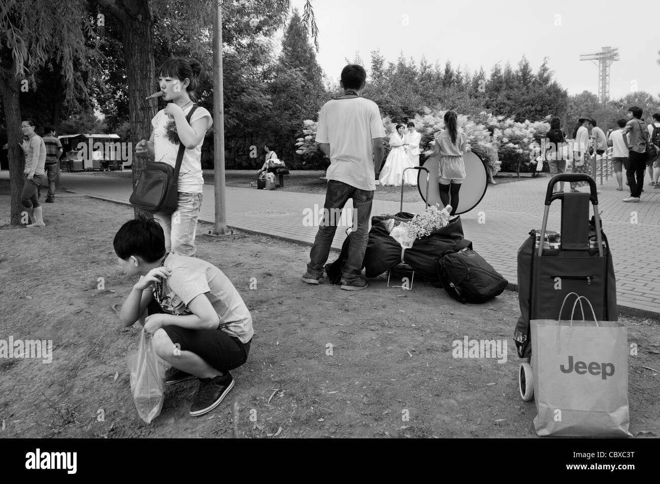 Parc de Chaoyang, Beijing. Les visiteurs dans le dos avec en arrière-plan une photo de mariage tournage. Banque D'Images