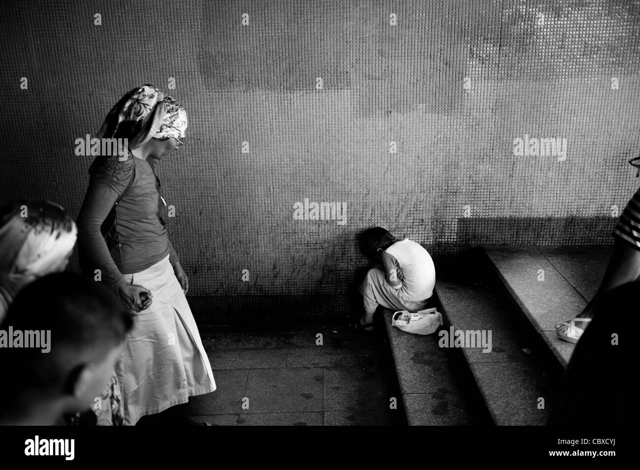 Galata, Istanbul. Les piétons passant par un jeune garçon sous le pont de Galata. Banque D'Images