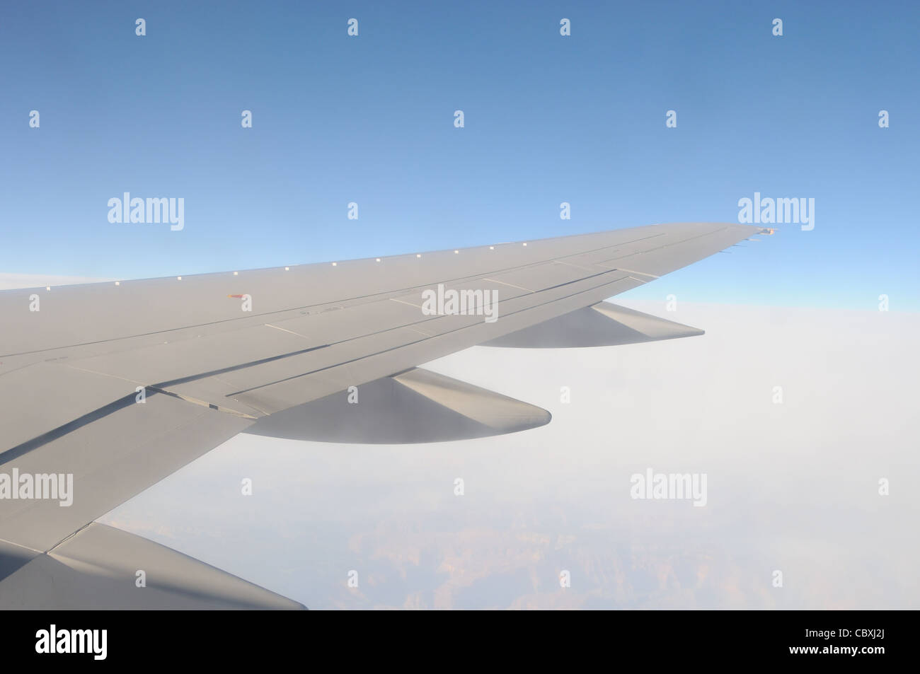 Photographie d'une aile à réaction en vol prises sur un ciel bleu matin en survolant les Rocheuses. Banque D'Images