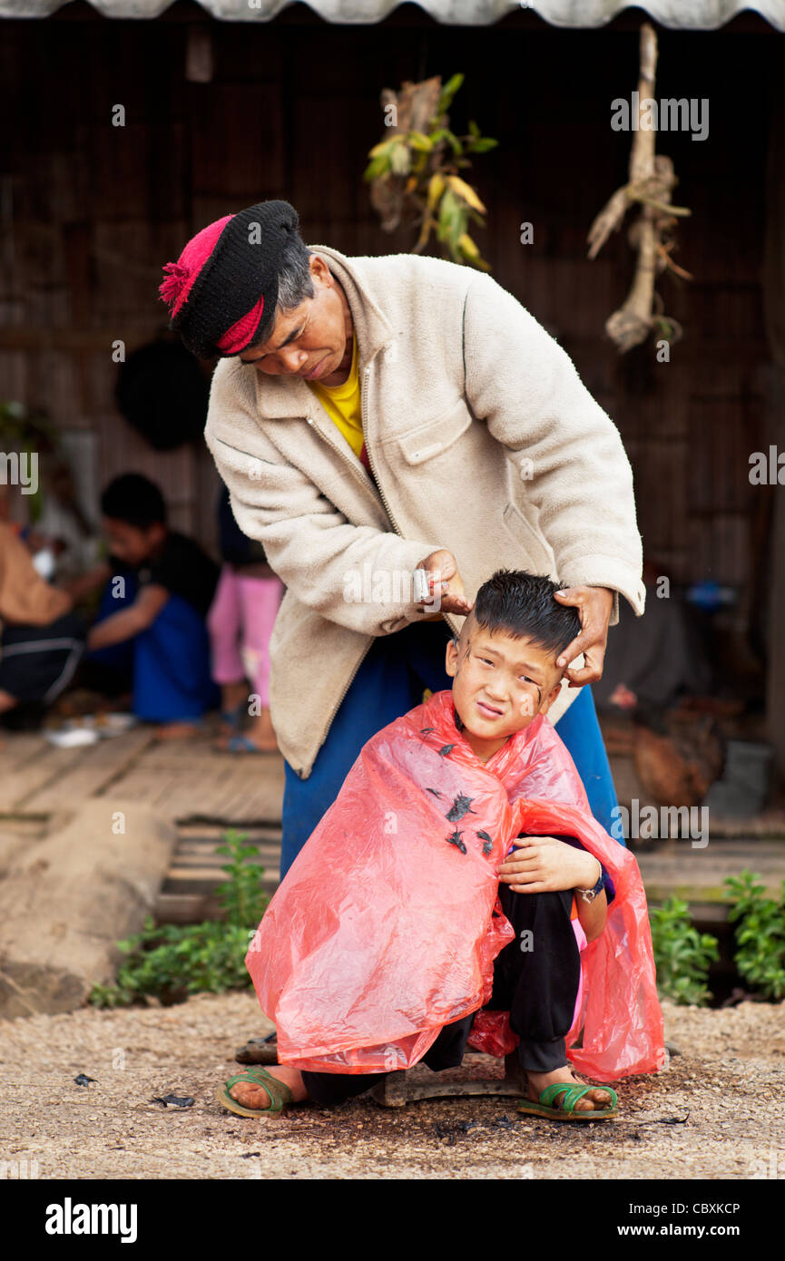 Palong boy getting une coupe à côté route dans Norlae, village du nord de la Thaïlande, en Asie. Banque D'Images
