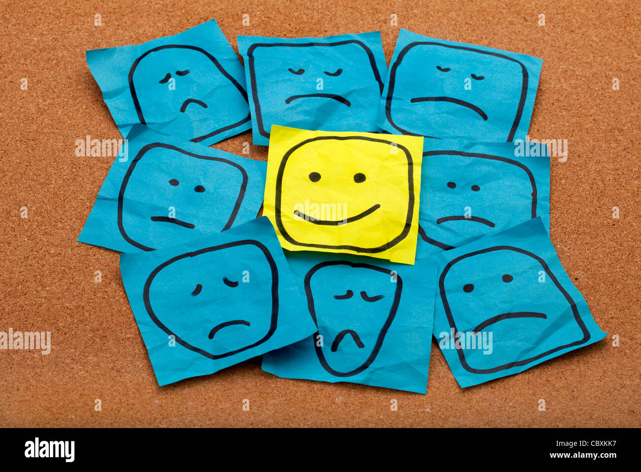 Attitude positive ou optimisme concept - heureux smiley sur Post-it jaune entourée de triste malheureux visages bleu Banque D'Images