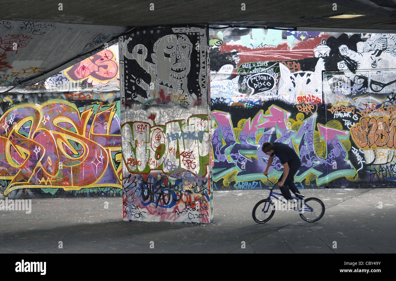 Rider BMX tricks en traction avant du mur de graffiti à Londres. L'image a été traitée dans Photoshop pour donner un sens graphique. Banque D'Images