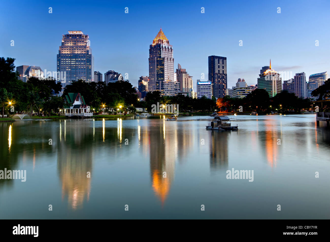 Vue vers Silom et Rama IV Road de parc Lumpini au crépuscule, Bangkok. Banque D'Images