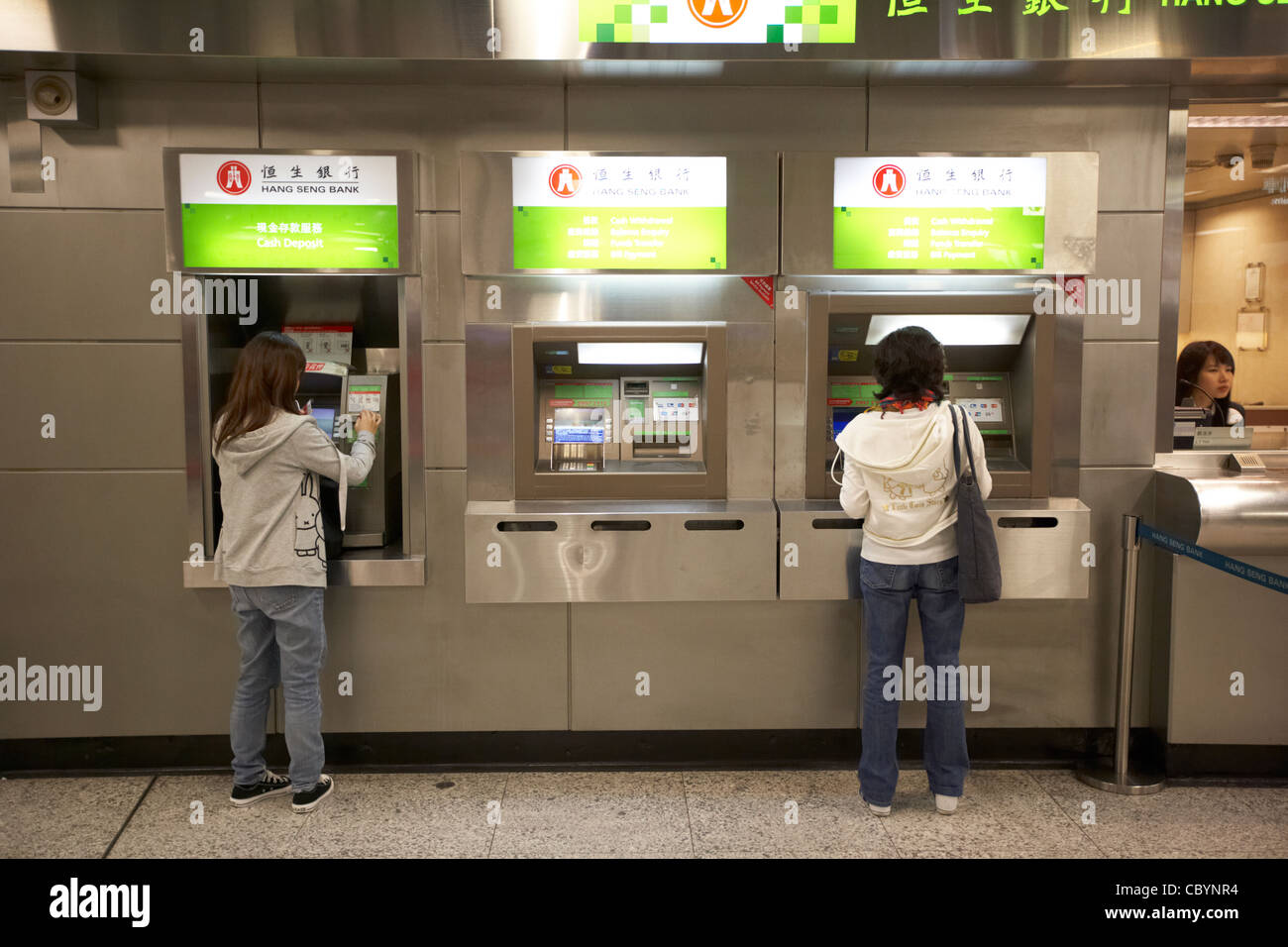 Les femmes chinoises à l'aide de Hang Seng Bank distributeur automatique de guichets automatiques bancaires à Hong Kong Hong Kong Chine Asie Banque D'Images