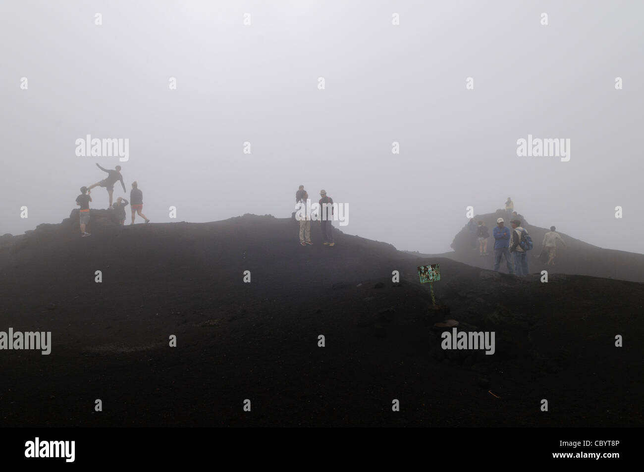 Un groupe de touristes posent pour des photos à un ciel nuageux et brumeux sommet du volcan Pacaya. Est un volcan actif Pacaya qui fait partie de l'arc volcanique d'Amérique centrale. Il forme une destination facilement accessible depuis la ville de Guatemala. Situé dans le Parc National de Pacaya, il culmine à 2 552 mètres (8 373 ft). Sa dernière éruption majeure, qui a causé beaucoup d'damange à proximité des villages et remodelé le sommet, a été en mai 2010. Cette éruption et cendres volcaniques dispersées sur une grande partie de la région, provoquant la fermeture des écoles et l'évacuation d'urgence et d'effacer une grande partie de la Banque D'Images