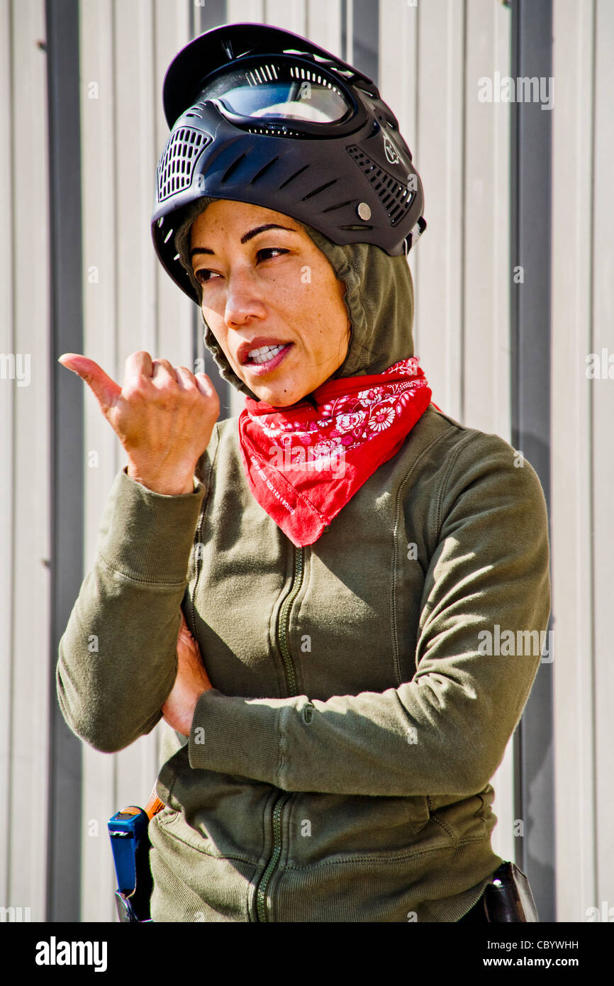 Une femelle Filipino-American agent d'application de la loi présente un exercice entrer dans une pièce avec des armes à un centre de formation à CA Banque D'Images