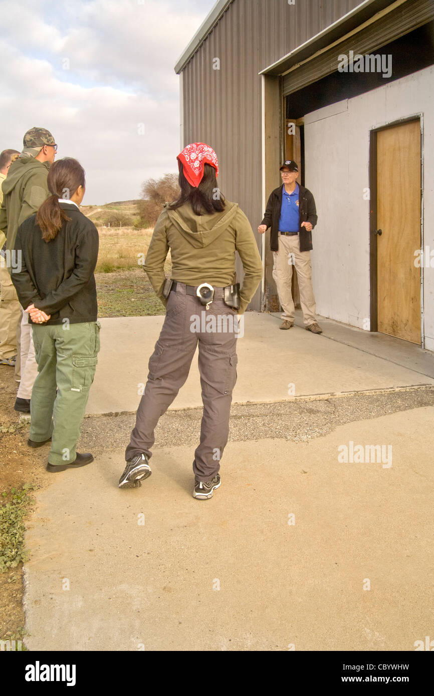 Une équipe d'agents d'application de la loi reçoivent des instructions sur les méthodes d'entrée ou 'violer' une chambre avec des armes à l'établissement de formation Banque D'Images