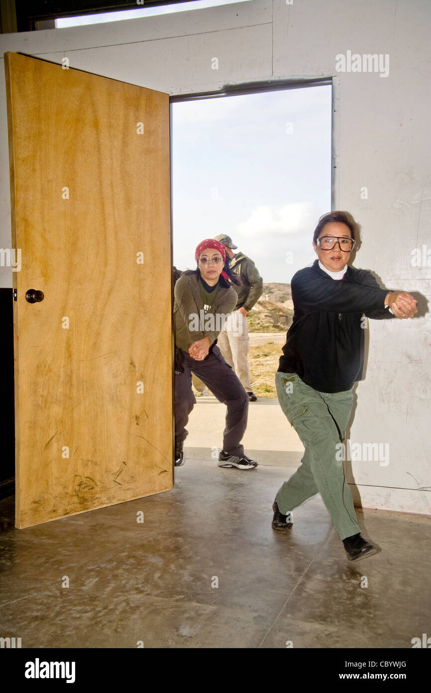 Se tenant la main où ils tiendraient une arme de poing, les femmes agents d'application de la pratique de la saisie d'un prix au centre de formation. Banque D'Images