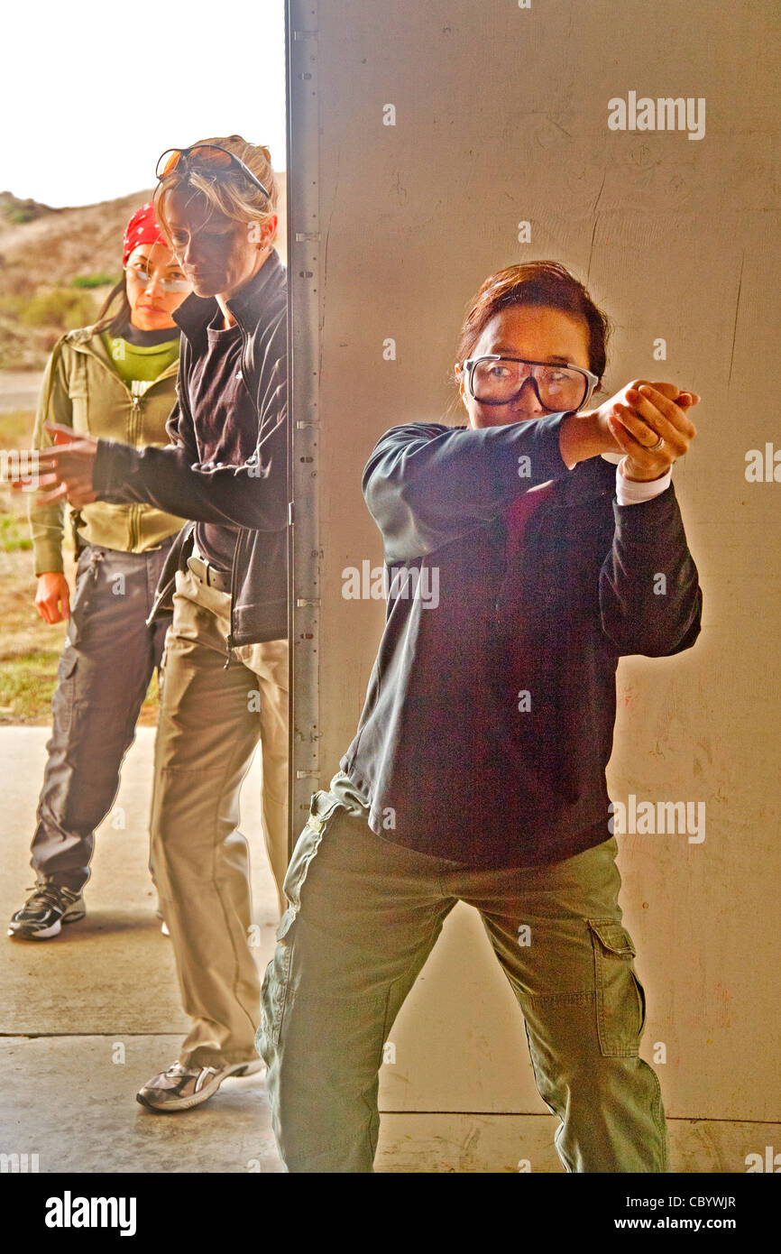 Se tenant la main où ils tiendraient une arme de poing, les femmes agents d'application de la pratique de la saisie d'un prix au centre de formation. Banque D'Images