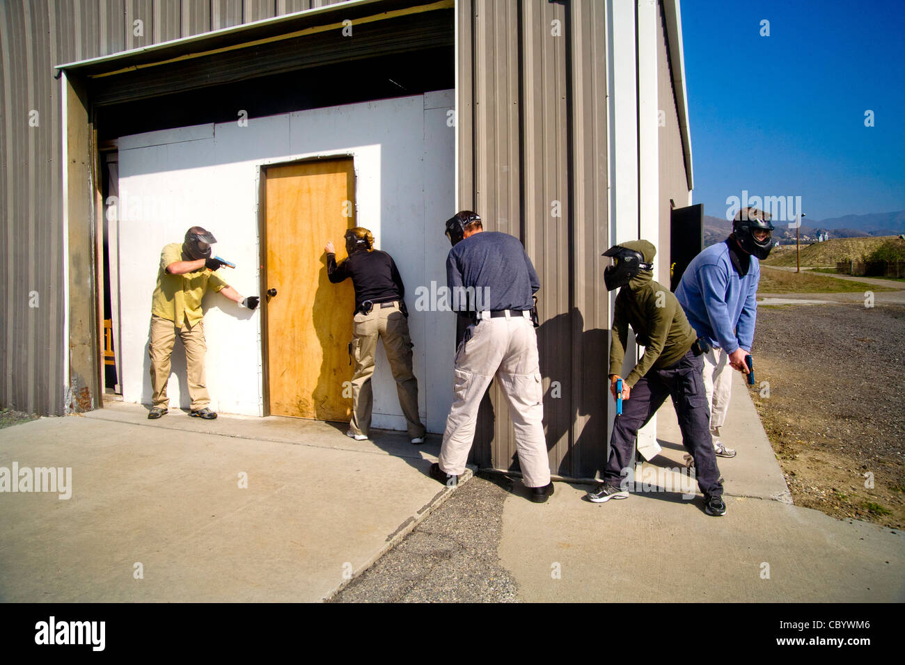 Le travail d'équipe, homme et femme femme les agents d'application de la pratique de la saisie d'un prix avec des armes à un centre de formation CA Banque D'Images