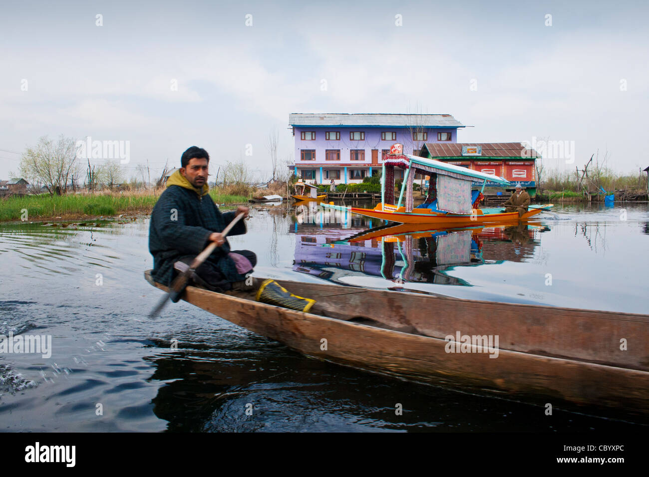 Un jeune homme chevauche son pays shakira en bateau le lac Dal Cachemire Banque D'Images