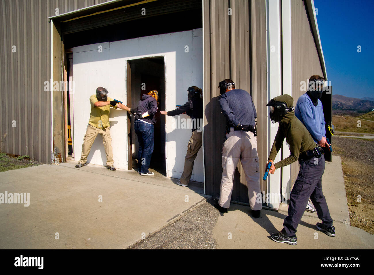 Le travail d'équipe, homme et femme femme les agents d'application de la pratique de la saisie d'un prix avec des armes à un centre de formation CA Banque D'Images