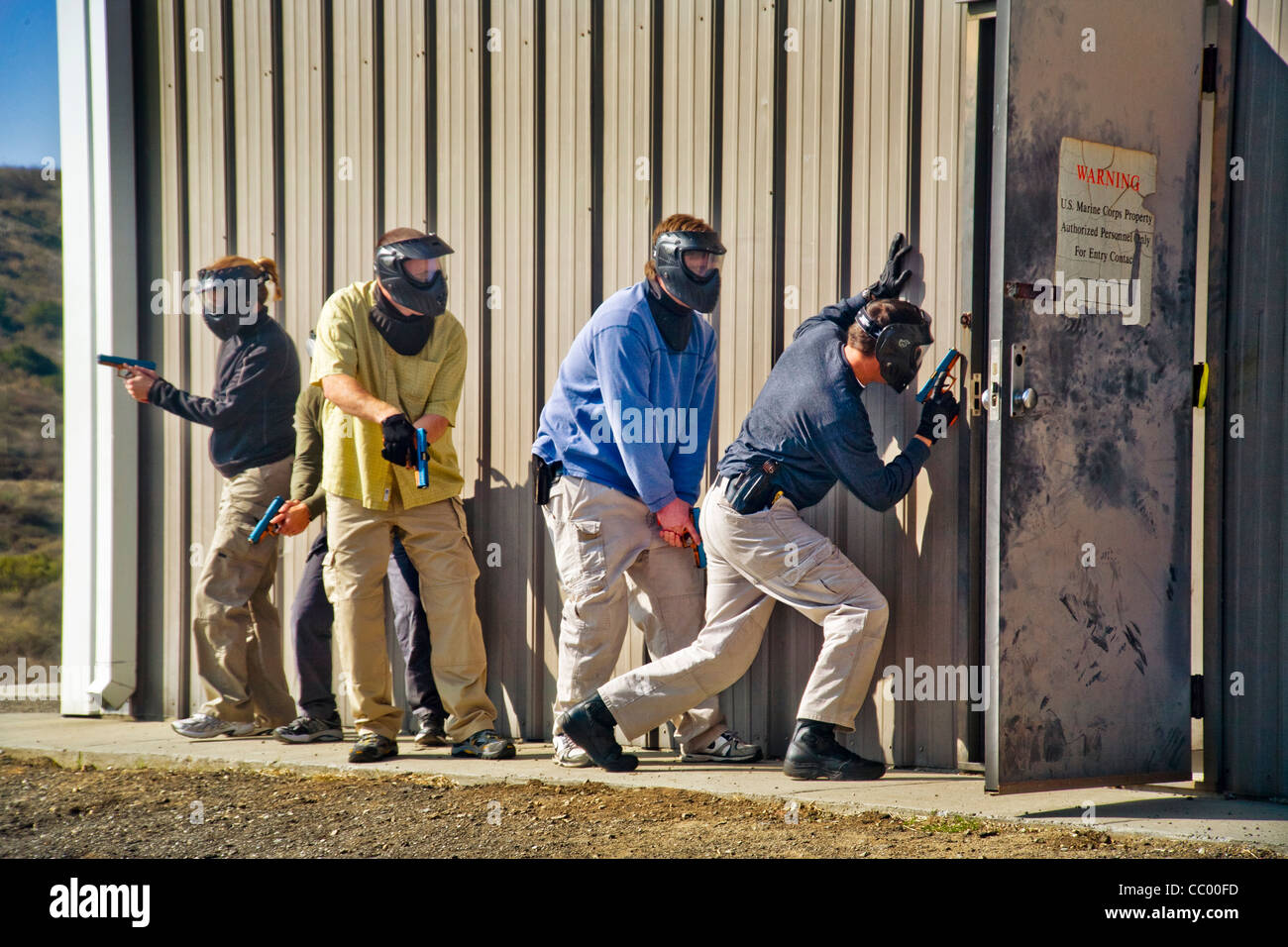 Le travail d'équipe, homme et femme femme les agents d'application de la pratique de la saisie d'un prix avec des armes à un centre de formation CA Banque D'Images