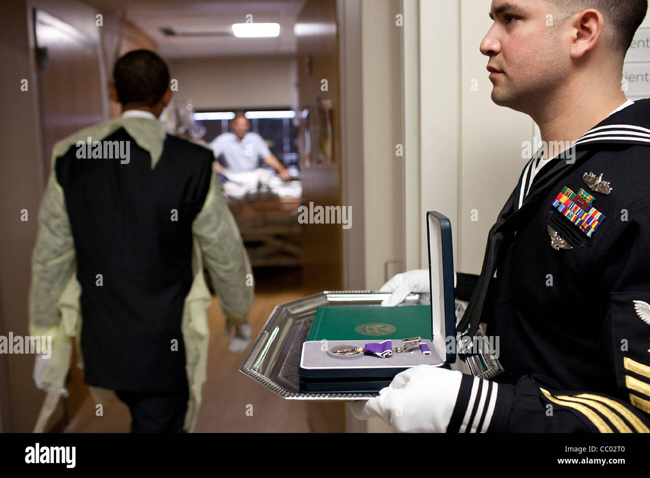 Le président Barack Obama portant une chemise d'hôpital se rend dans une chambre d'hôpital d'un soldat blessé à présent la Purple Heart médaille à Reed National Military Medical Center le 10 octobre 2011 à Bethesda, MD. Banque D'Images