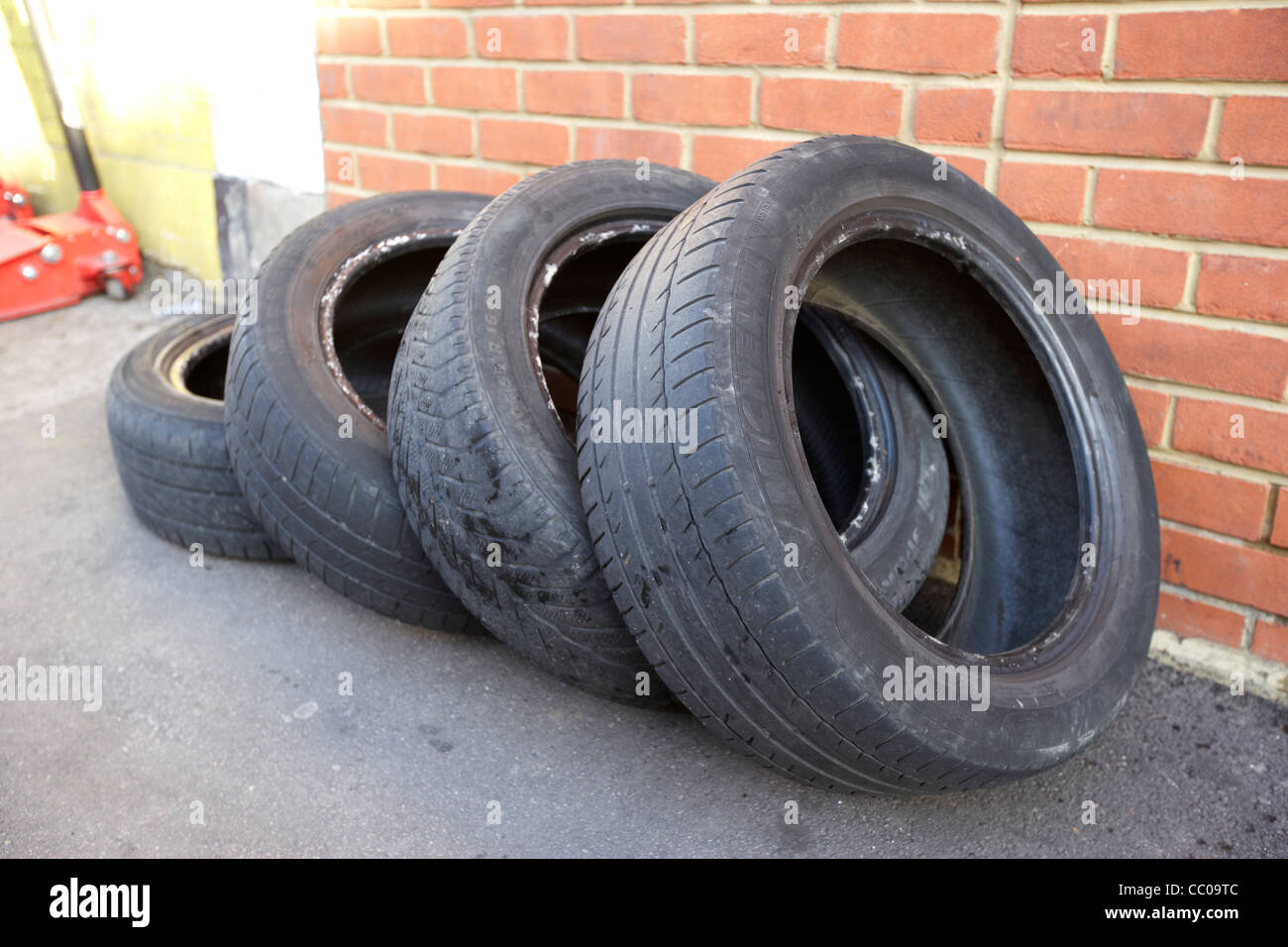 Partie quatre vieux pneus usés utilisés se trouvant à l'extérieur d'un garage à Londres Angleterre Royaume-Uni Royaume-Uni Banque D'Images