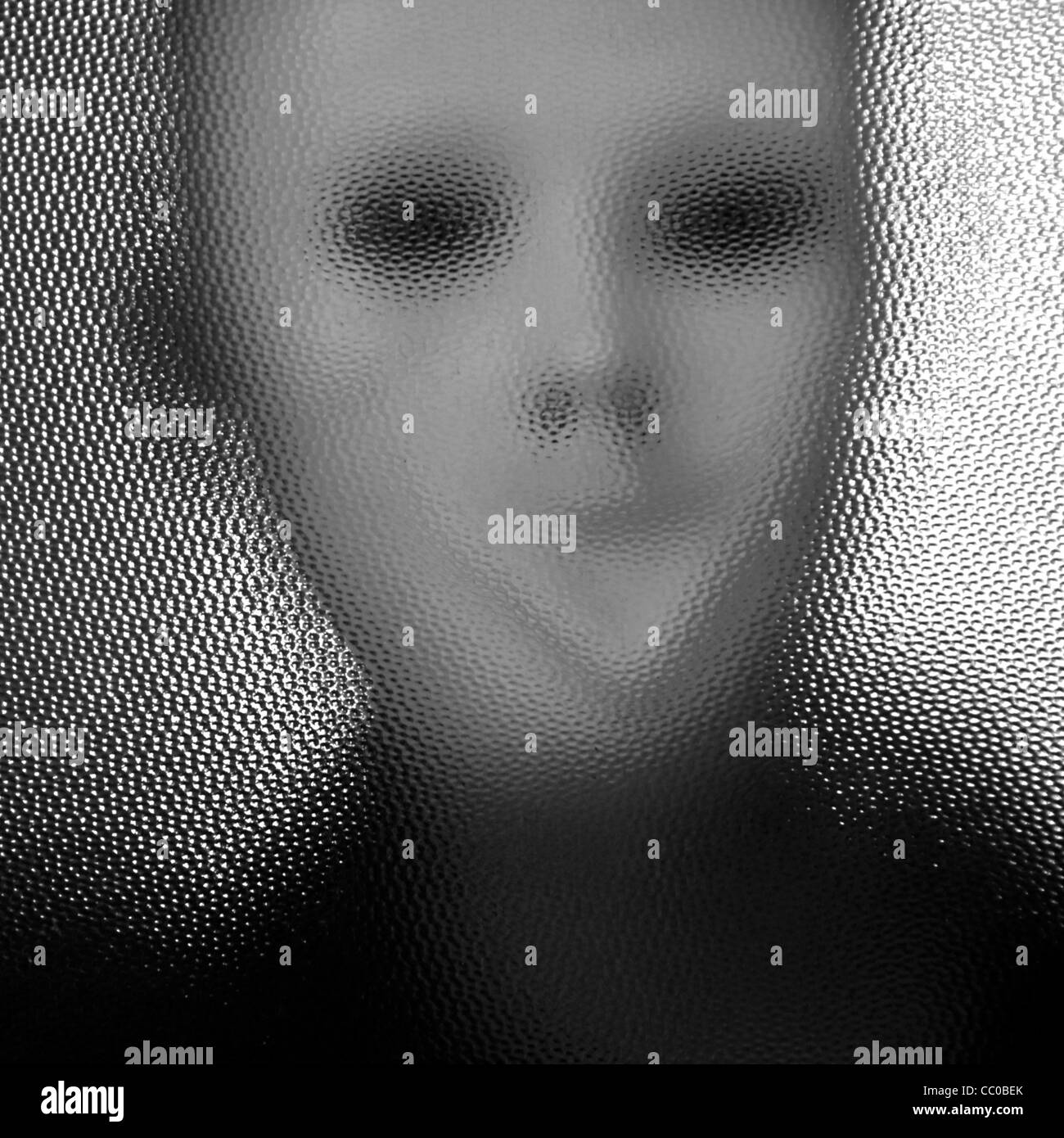 La figure déformée masqué derrière la surface en verre teinté. Noir et blanc. Banque D'Images