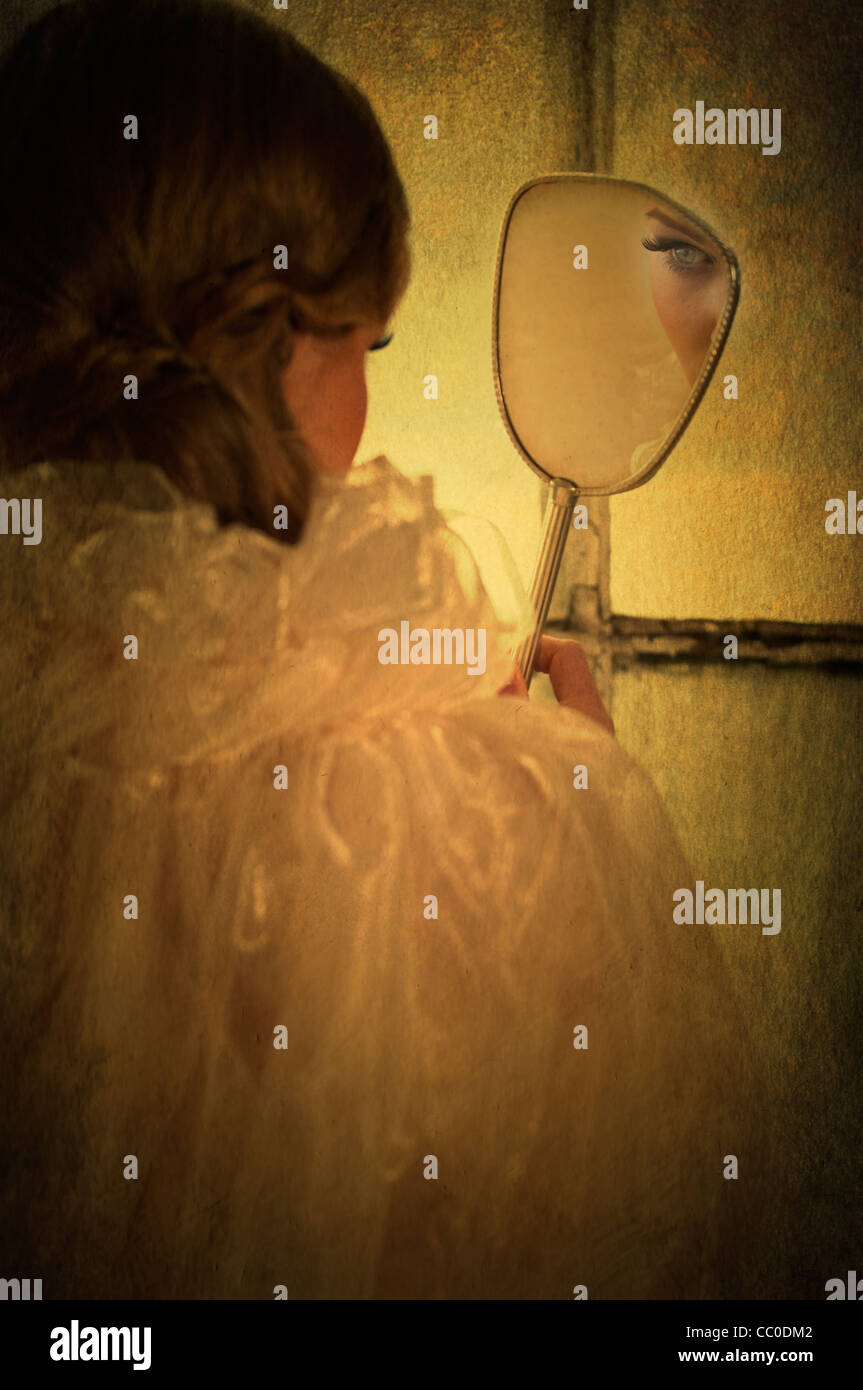 Vue arrière d'une femme à la recherche dans un miroir Banque D'Images