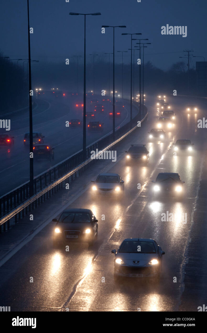 Les voitures et le trafic d'un soir de pluie humide sur l'autoroute britannique.La conduite dans des conditions hivernales dangereuses. Banque D'Images