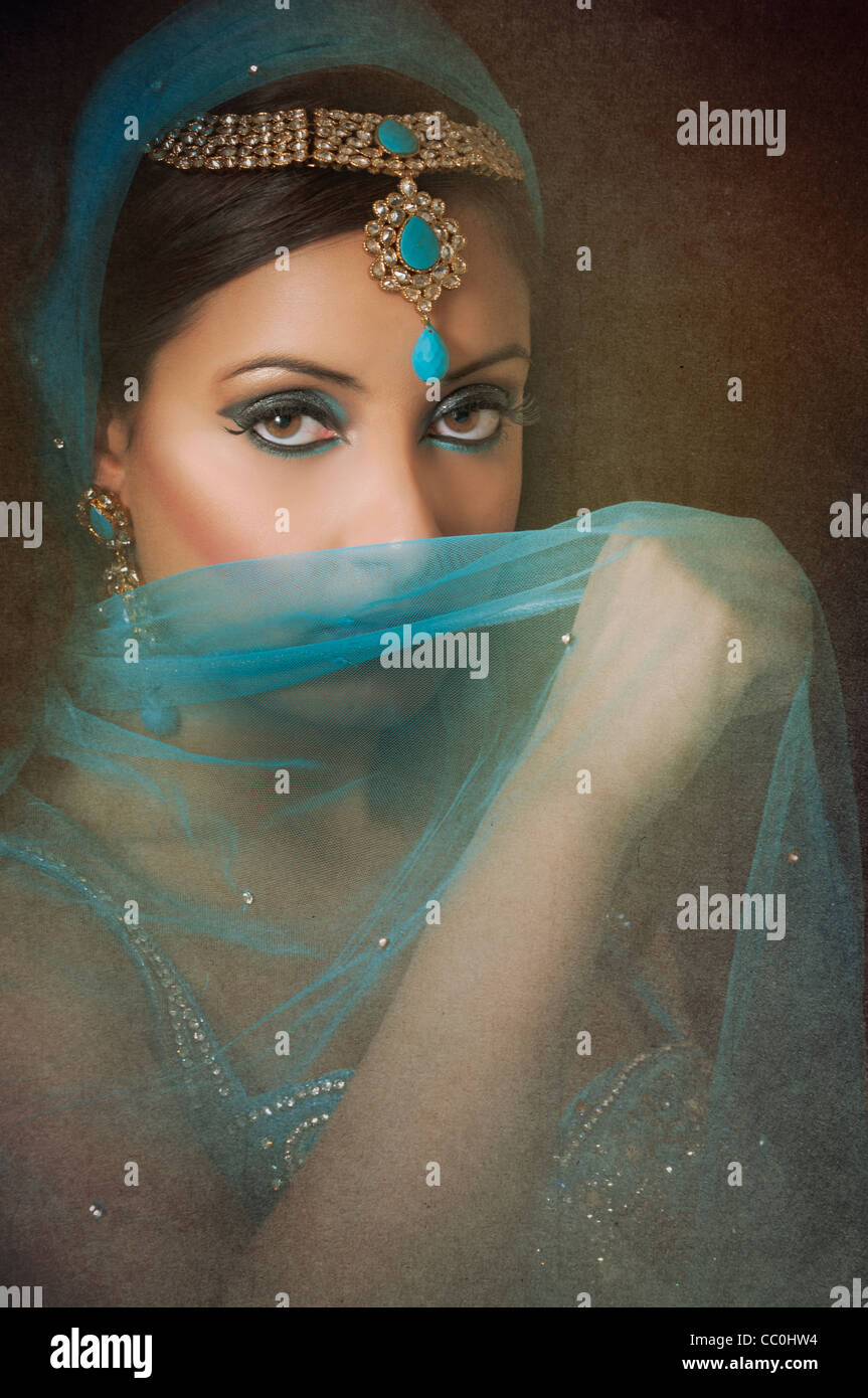 Belle femme indienne se cachant le visage avec un voile bleu Banque D'Images