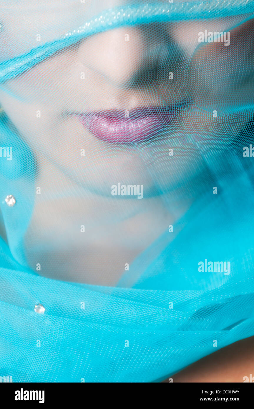 Détail d'une bouche de femme couverte d'un voile bleu Banque D'Images
