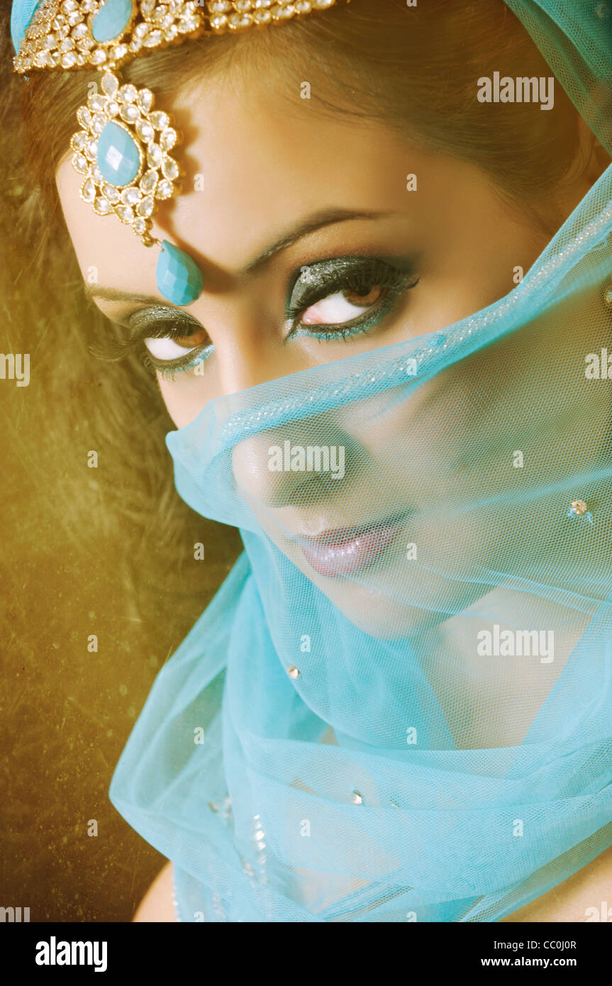 Femme indienne grave couvrant son visage avec voile bleu à la suite Banque D'Images