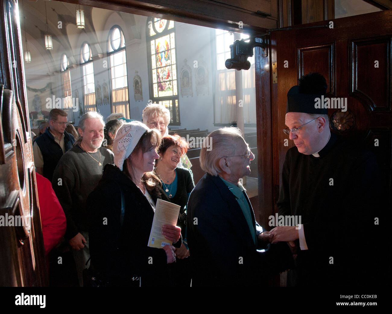 Père Christopher Stainbrook, droite, un prêtre Anglican catholique convertit) accueille après la messe inaugurale Banque D'Images