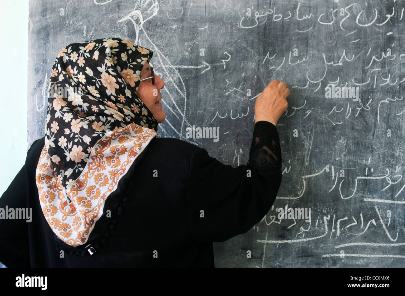 Mazar l'école. Un enseignant écrit sur le tableau noir Banque D'Images