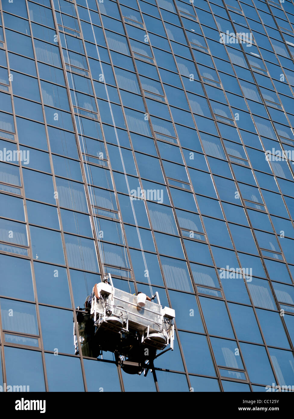 Window Washer est laver les vitres d'un immeuble de bureaux en verre moderne en centre-ville de Grand Rapids, Michigan USA. Banque D'Images