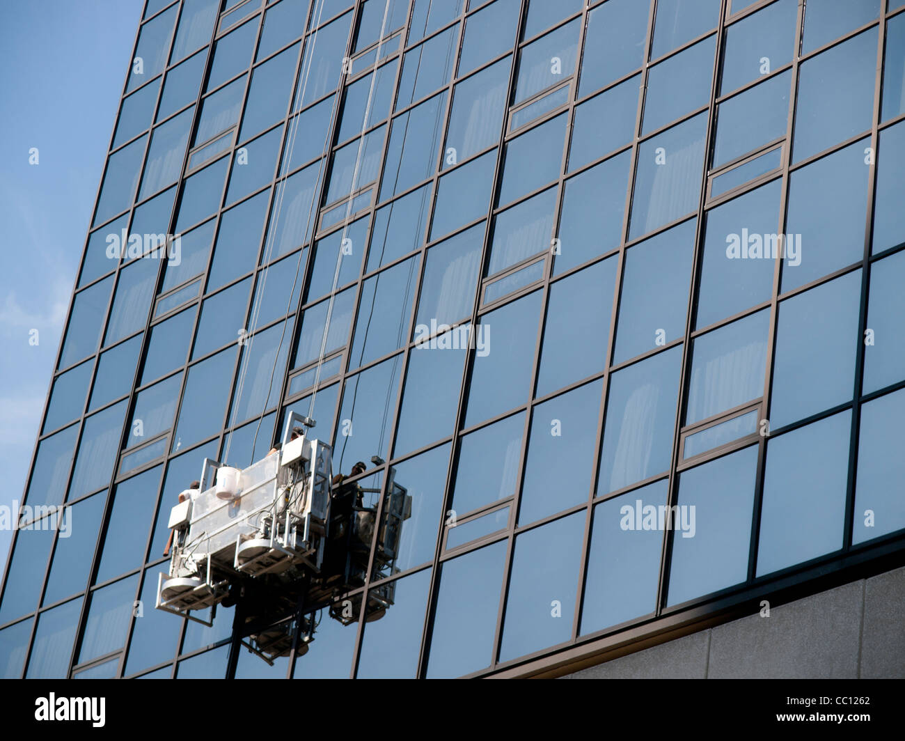 Window Washer est laver les vitres d'un immeuble de bureaux en verre moderne en centre-ville de Grand Rapids, Michigan USA. Banque D'Images