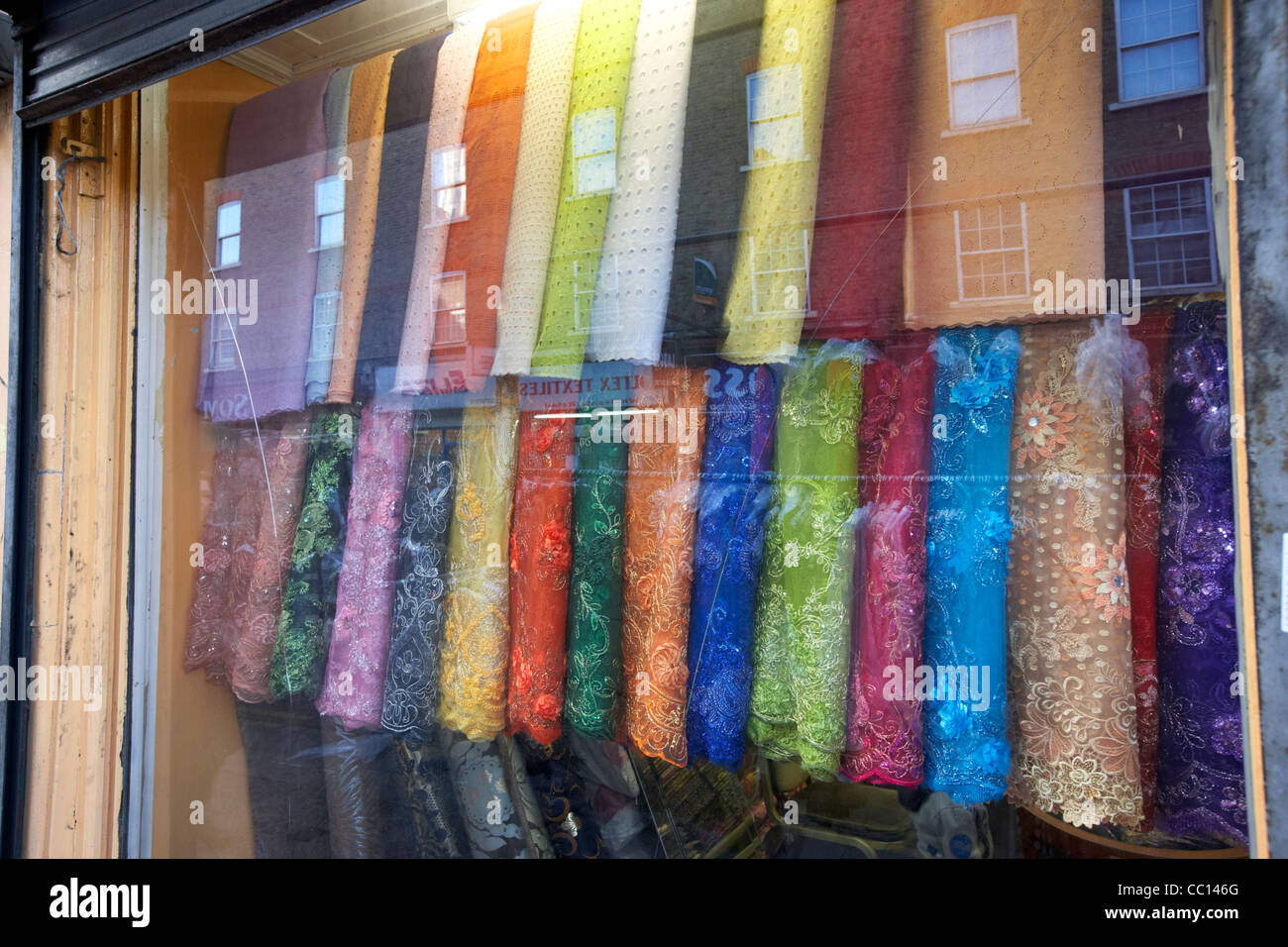 Matériaux colorés suspendus dans la fenêtre d'un magasin de vêtements de mode et le jupon Lane London England uk united kingdom Banque D'Images