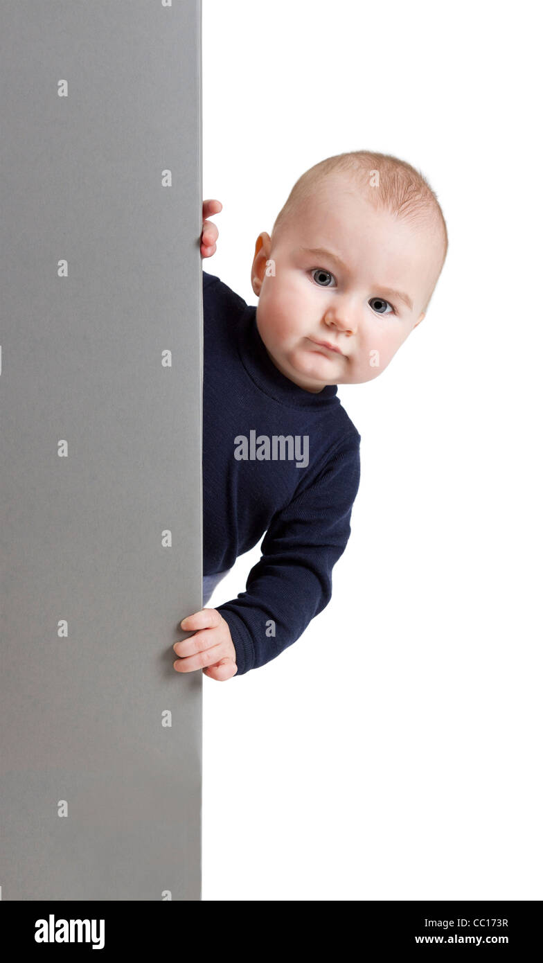 Jeune enfant tenant vertical, gray signe. isoler sur fond blanc Banque D'Images