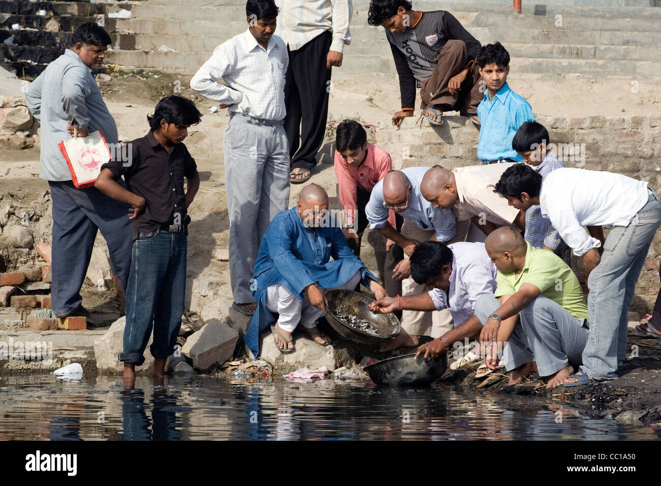 Les hommes dispersent les cendres dans la rivière Yamuna dans le cadre d'un rite funéraire, Nigambodh Ghat, New Delhi, Inde Banque D'Images Les hommes dispersent les cendres dans la rivière Yamuna dans le cadre d'un rite funéraire, Nigambodh Ghat, New Delhi, Inde Banque D'Images