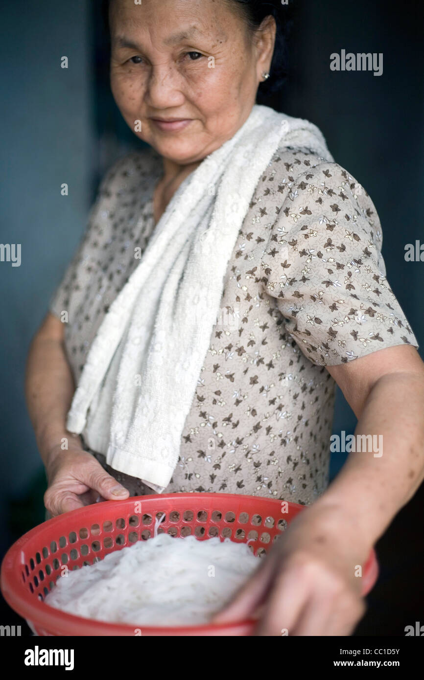 Une grand-mère avec un bol de nouilles fraîches sur sa ferme familiale, Tay Ninh, Vietnam Banque D'Images