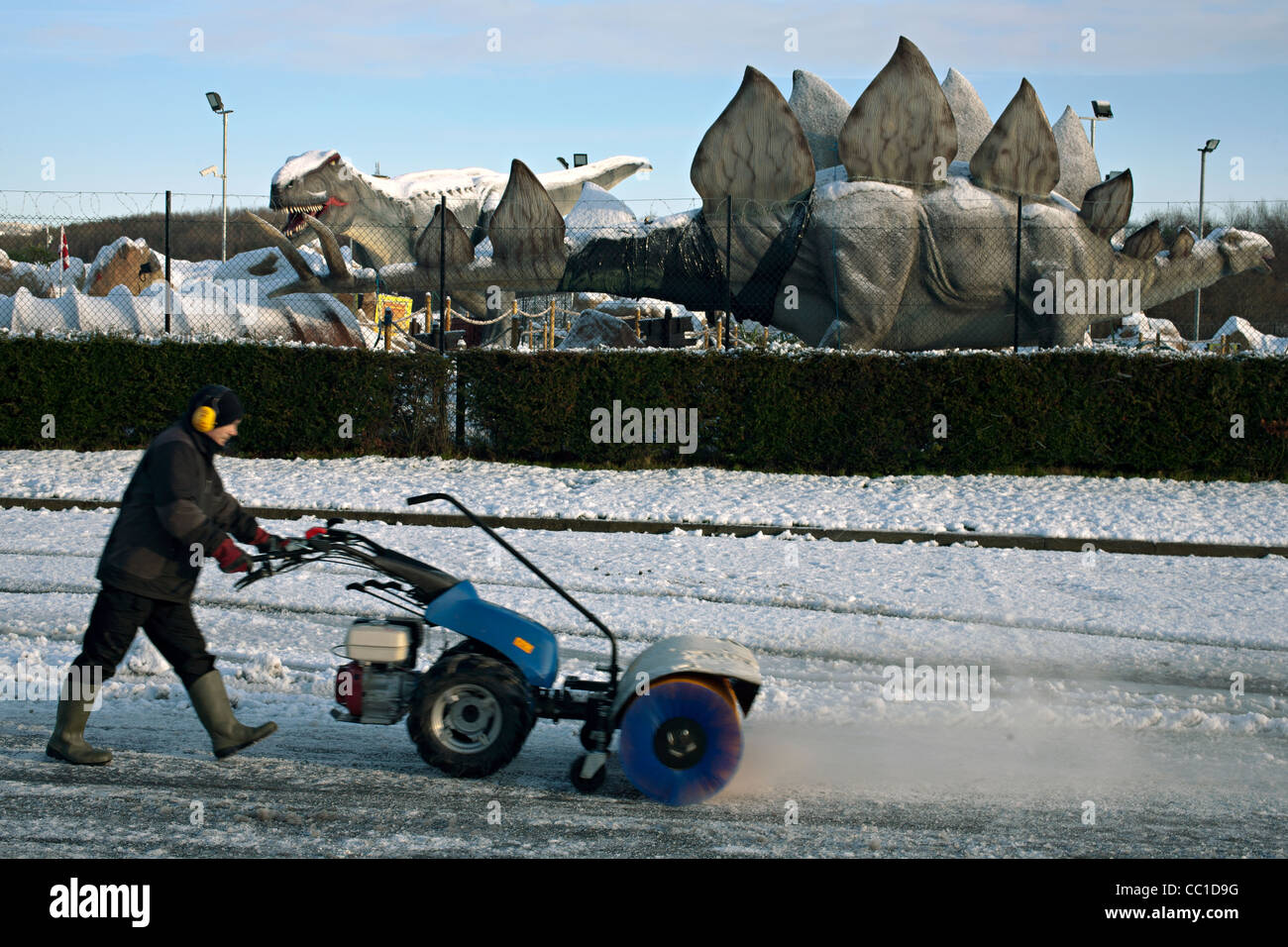Balayage de la neige à l'extérieur du parc à thème dinosaur Glasgow Banque D'Images