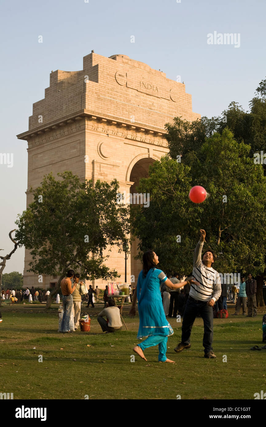 Un couple jouer avec un ballon rouge par la porte de l'Inde, New Delhi, Inde Banque D'Images