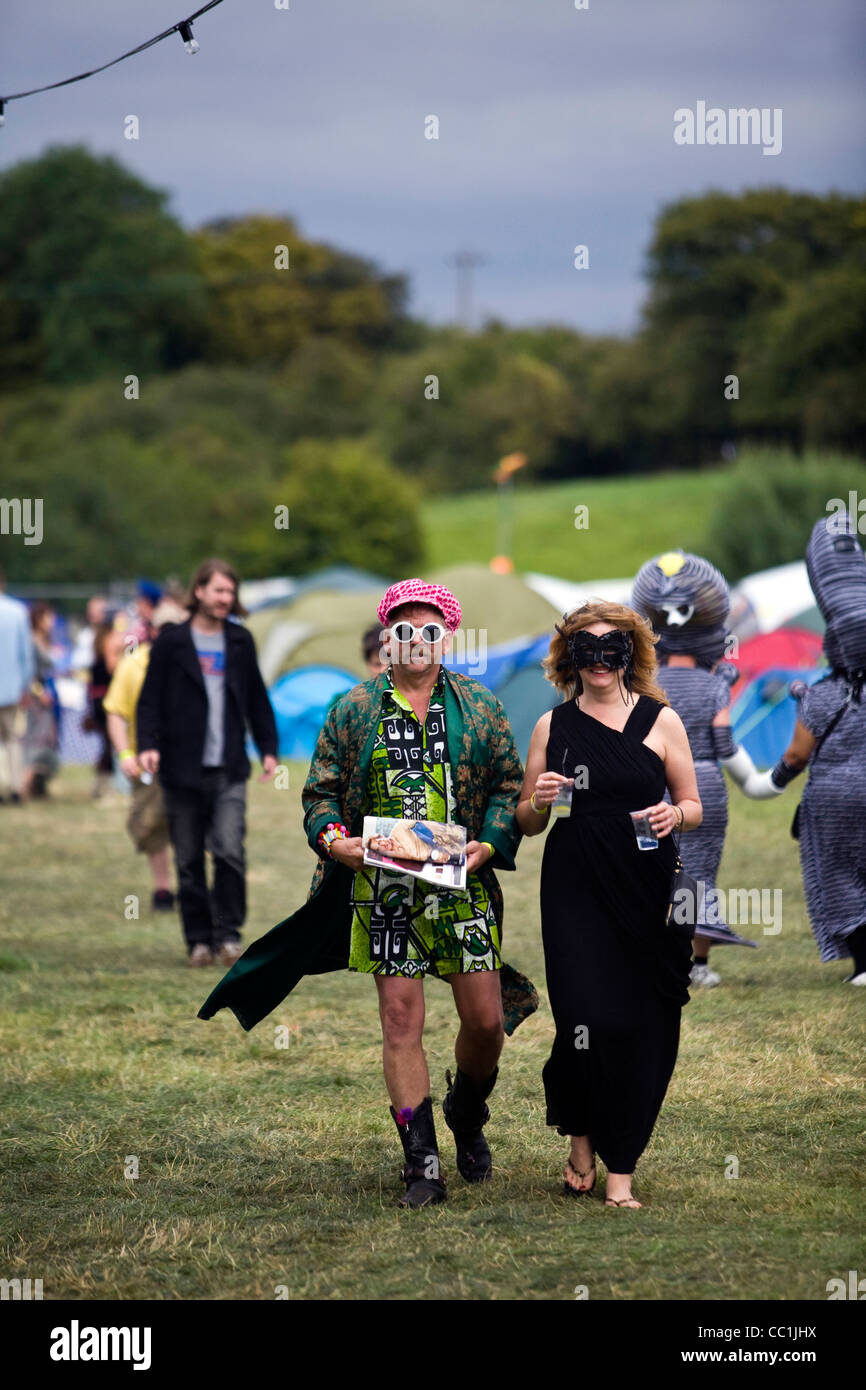 Un homme et une femme en costume de marche à travers un champ à l'appelant Standon Festival à Hertfordshire, Royaume-Uni Banque D'Images