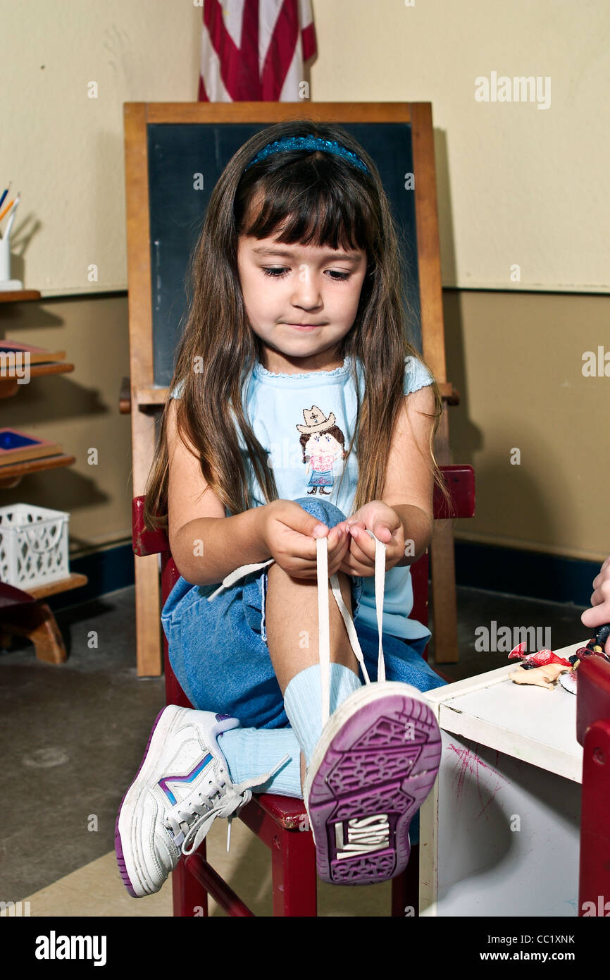 4-5 ans ans girl learning pour attacher ses chaussures en classe. M. © Myrleen Pearson Banque D'Images