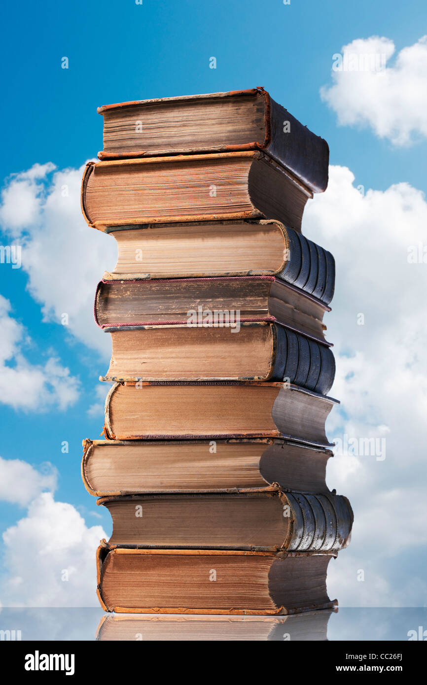 Les vieux livres d'une pile avec le fond de ciel. Banque D'Images