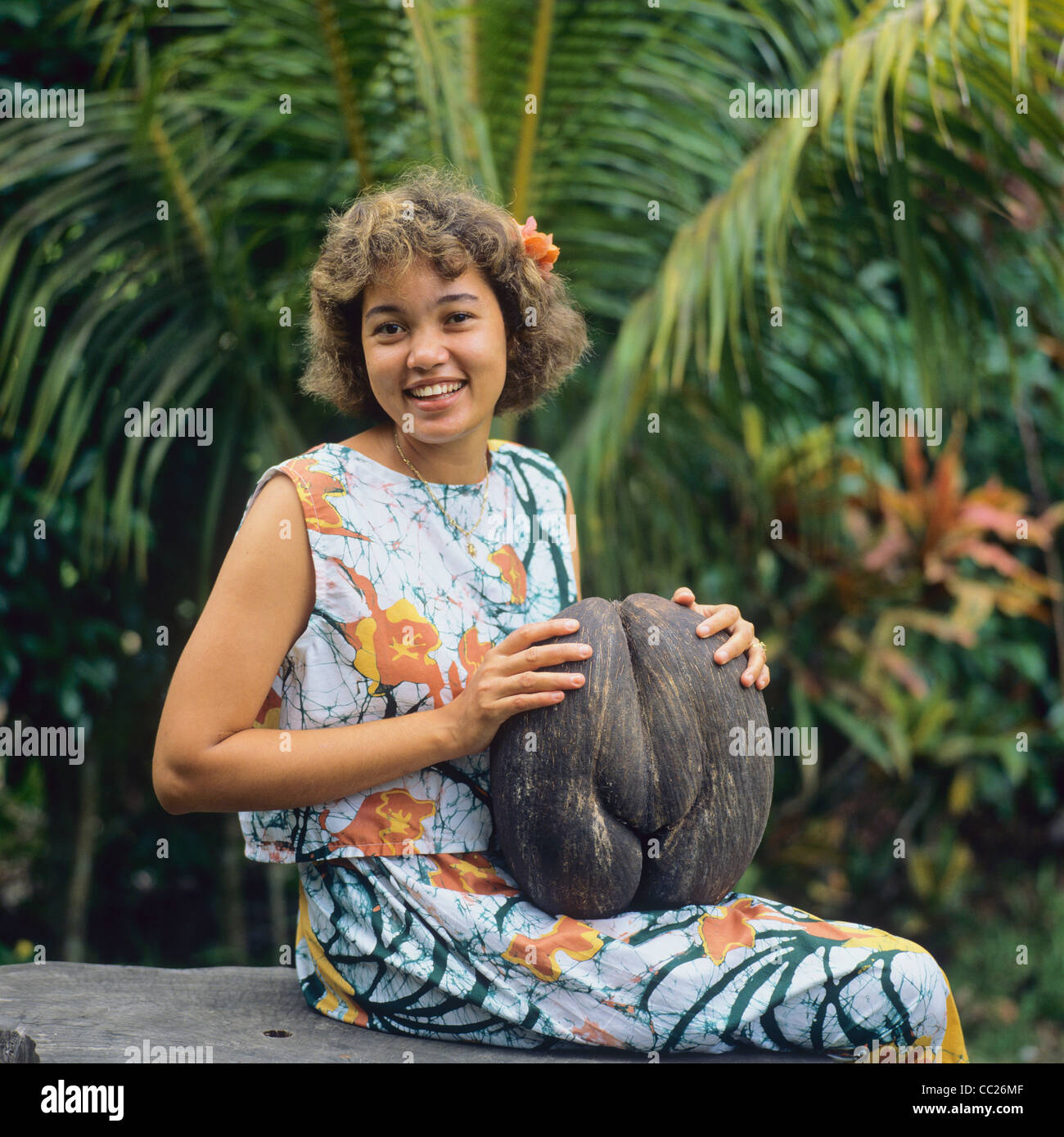 Jeune femme Créole avec un écrou de Coco de Mer, l'île de Praslin, Seychelles, Afrique Banque D'Images