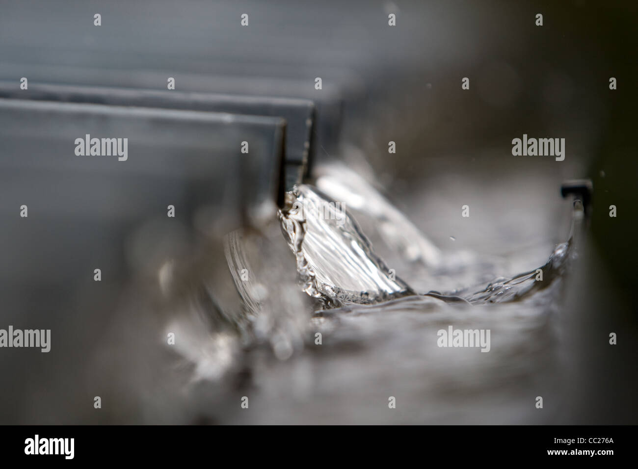 L'eau de pluie qui s'écoule dans une gouttière à une surface de Banque D'Images