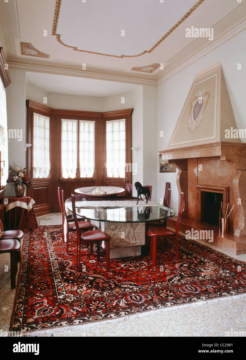 Salle à manger avec cheminée en marbre et grand tapis dans une ancienne résidence Banque D'Images