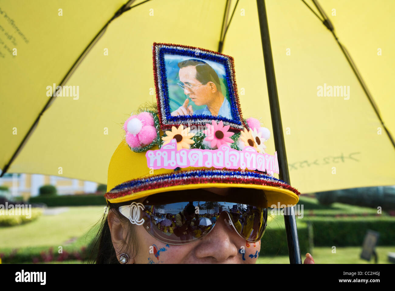Woman wearing cap décoré avec une image du monarque, le Roi Bhumibol Adulyadej. Bangkok, Thaïlande Banque D'Images