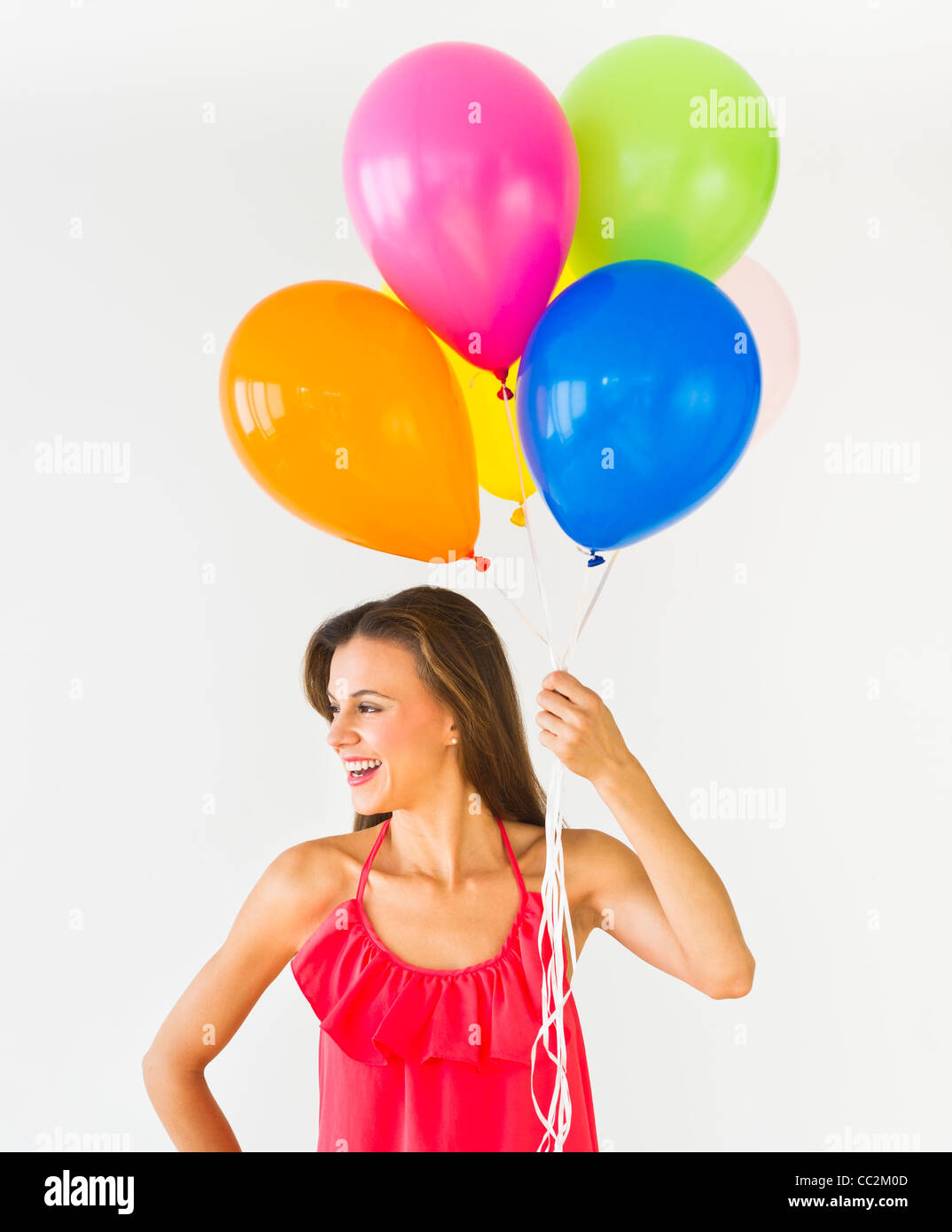 Smiling woman holding balloons, studio shot Banque D'Images